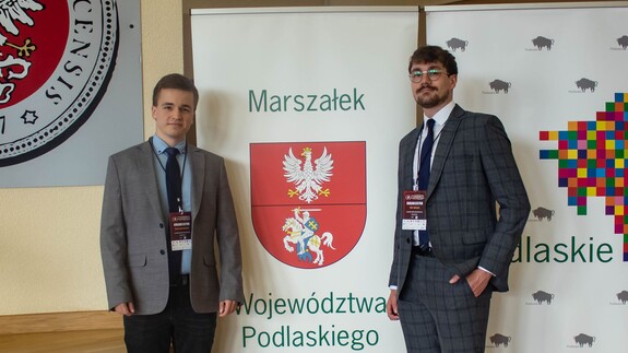 Uczestnicy konferencji pozują do zdjęcia przy banerze Marszałka Województwa Podlaskiego