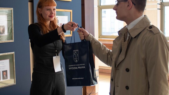 Uczestnik konferencji odbiera pakiet
